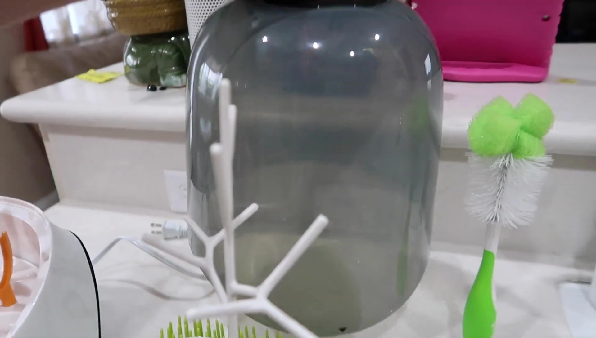 Demonstrating the process of filling the sterilizer with water and placing bottles inside.