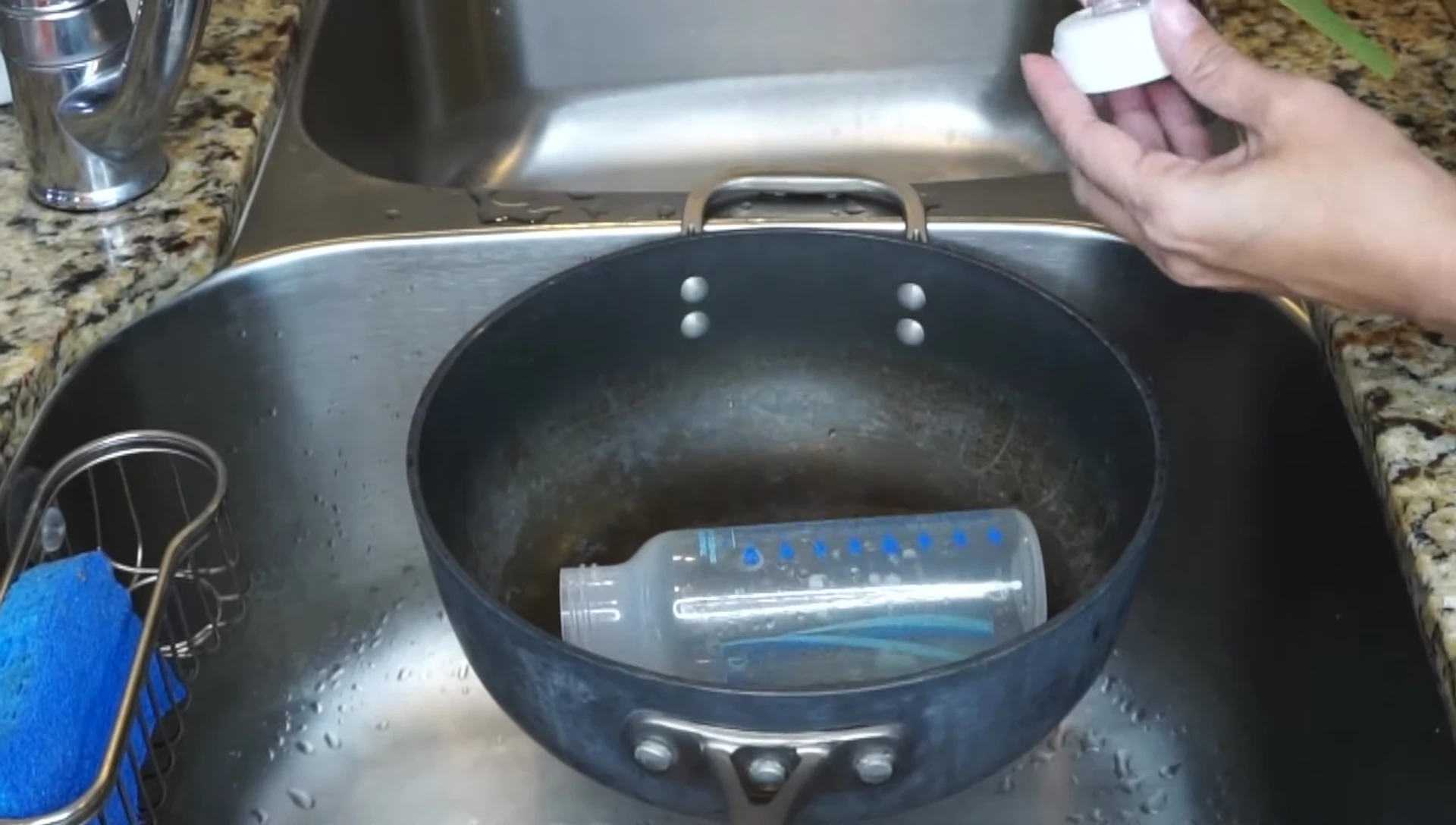 Pot of boiling water with baby bottles submerged.