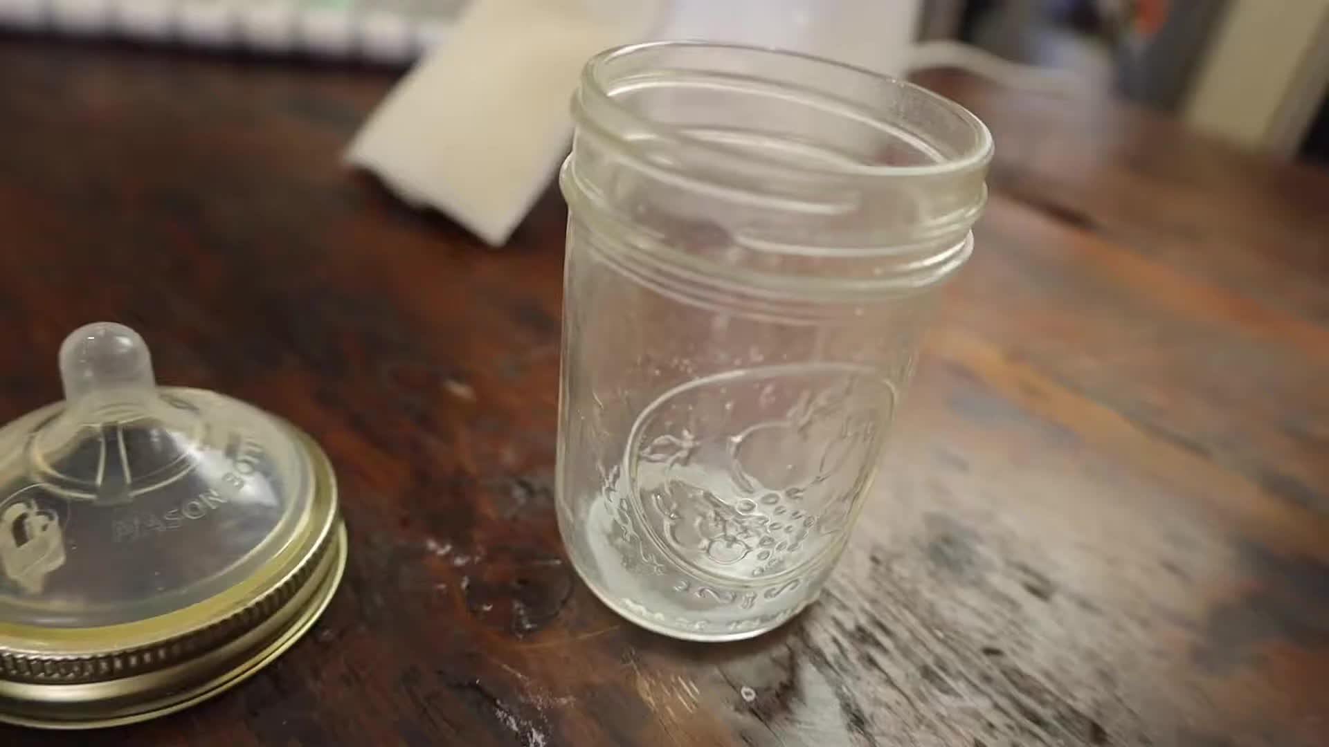 Mason jar nipples attached to mason jars for feeding the baby.