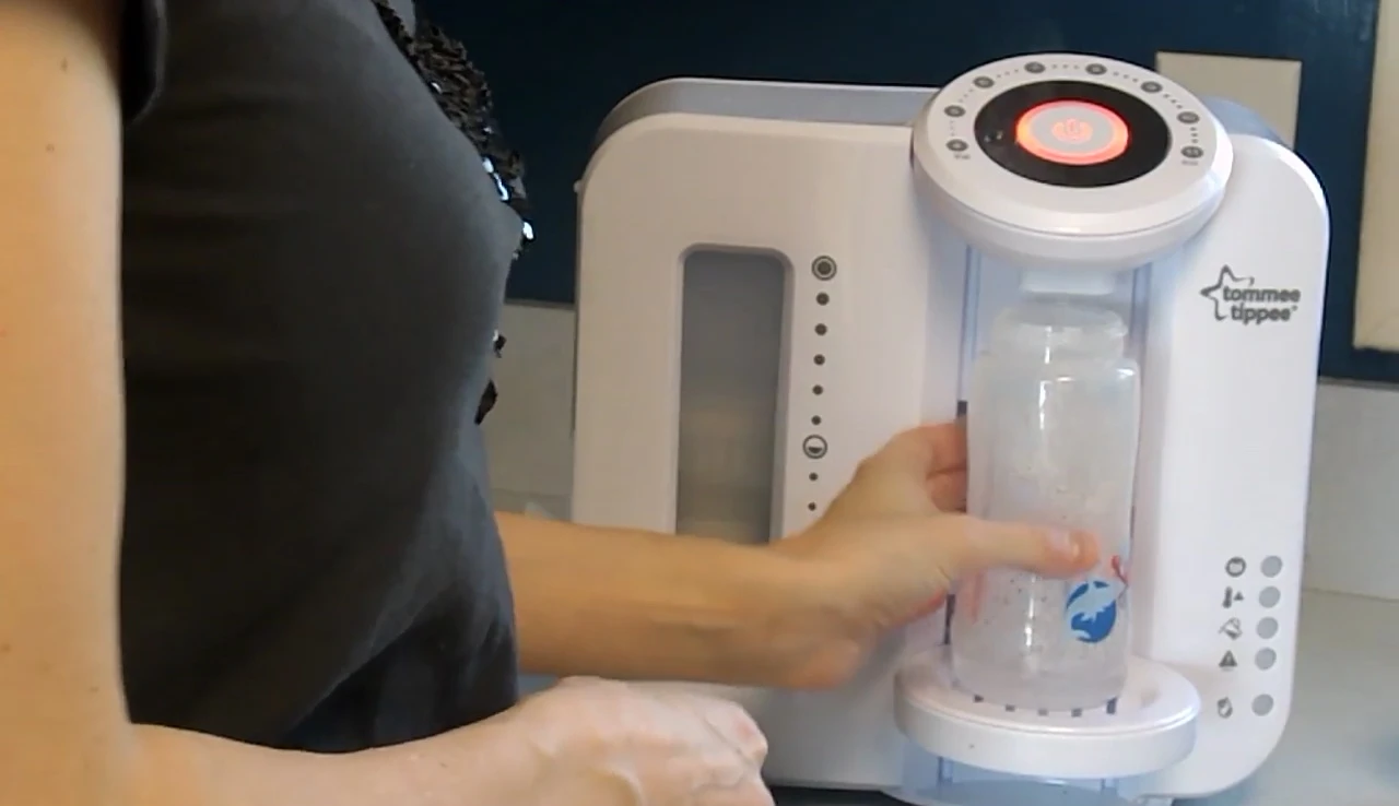 Removing the bottle after the initial hot water dispense.
