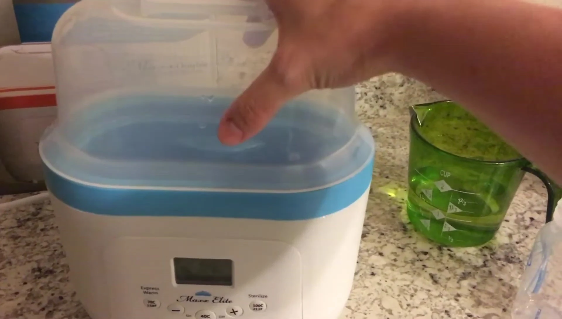 Demonstrating the placement of bottles and accessories in the unit for sterilization.