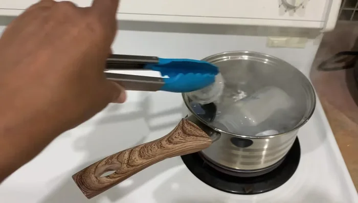 Remove the sterilized items using tongs and place them on a clean paper towel or cloth to cool.