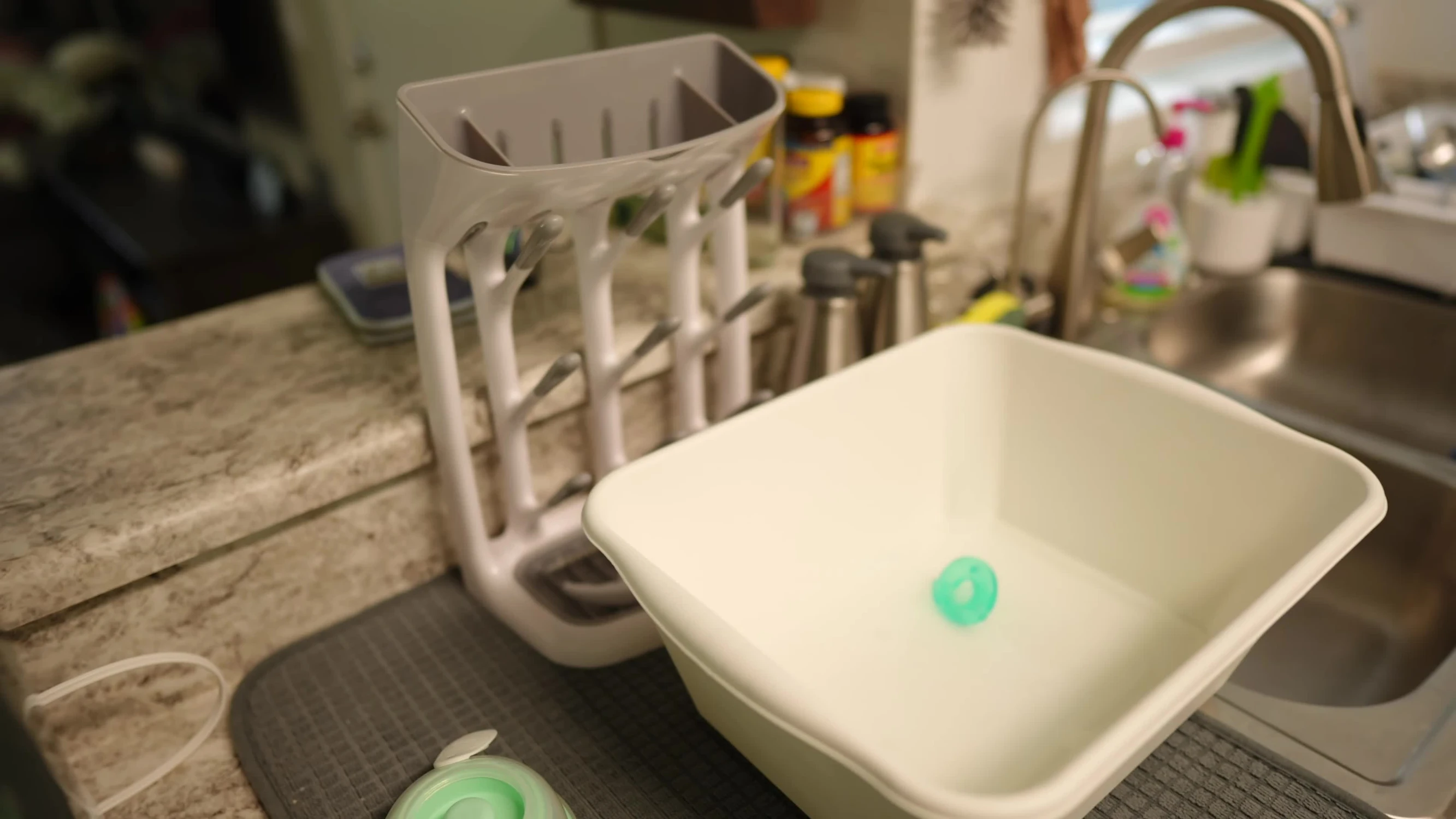 A shot of a rack and a bucket full of pump parts and bottles, highlighting the cleaning burden.