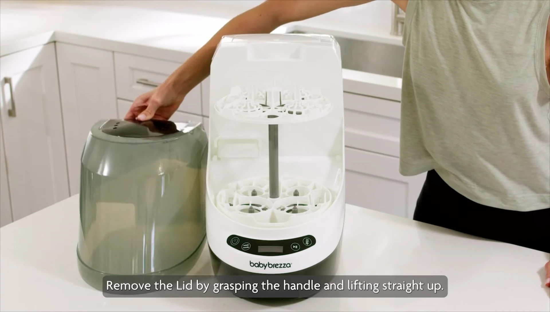 Placing bottles on the lower rack of the Baby Brezza Bottle Washer Pro.