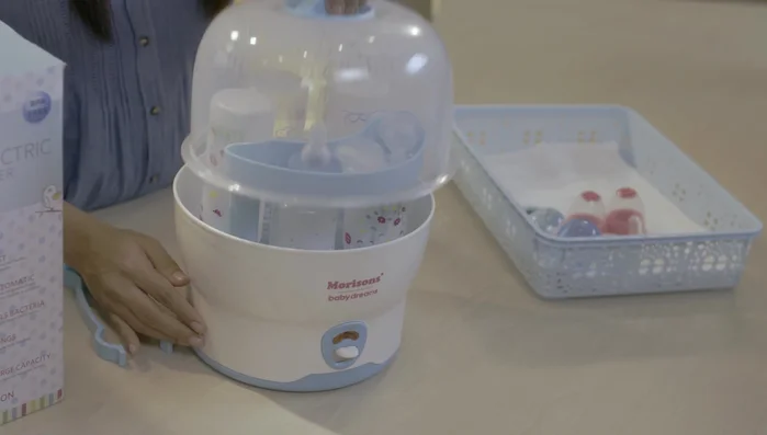 Use the tongs to remove the sterilized bottles.