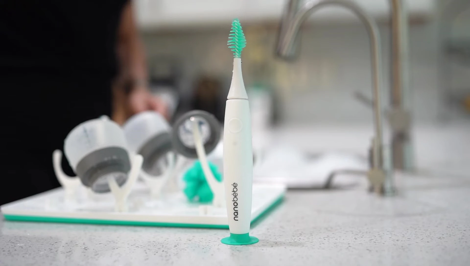 A demonstration of the E-Brush easily cleaning a bottle, highlighting the minimal pressure needed.